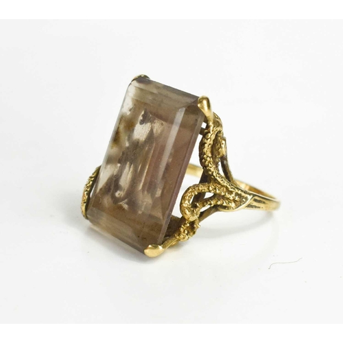 136 - A 9ct gold and smoky quartz dress ring, the quartz measures 2.5 by 2cm, in a four claw setting embel... 