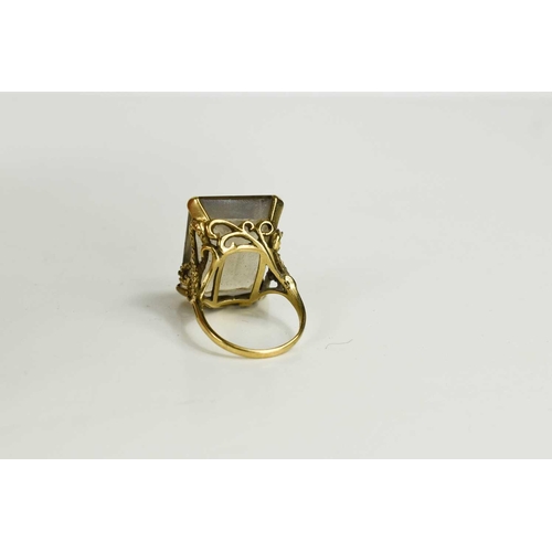 136 - A 9ct gold and smoky quartz dress ring, the quartz measures 2.5 by 2cm, in a four claw setting embel... 