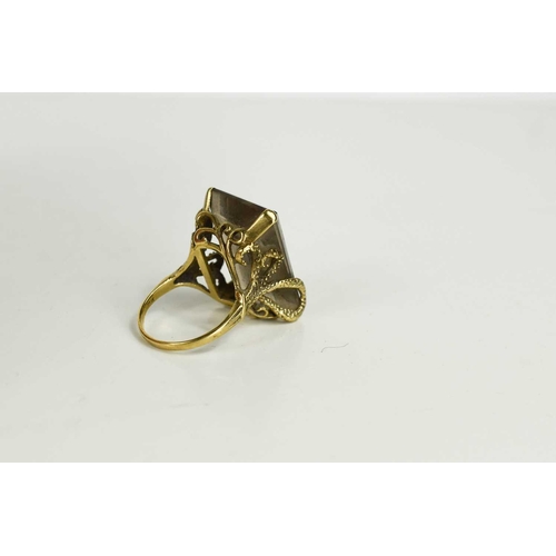 136 - A 9ct gold and smoky quartz dress ring, the quartz measures 2.5 by 2cm, in a four claw setting embel... 