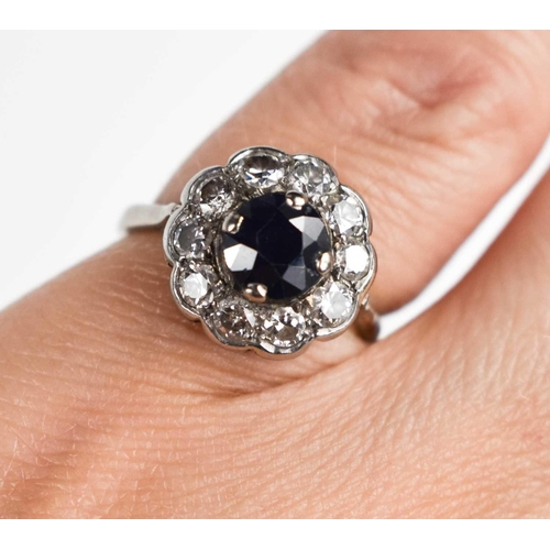 154 - A rose cut diamond and sapphire flowerhead ring, the central dark sapphire surrounded by ten diamond... 