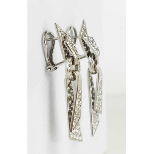 171 - A pair of 18ct white gold and diamond encrusted modernist design drop earrings, the folded ribbon ef... 