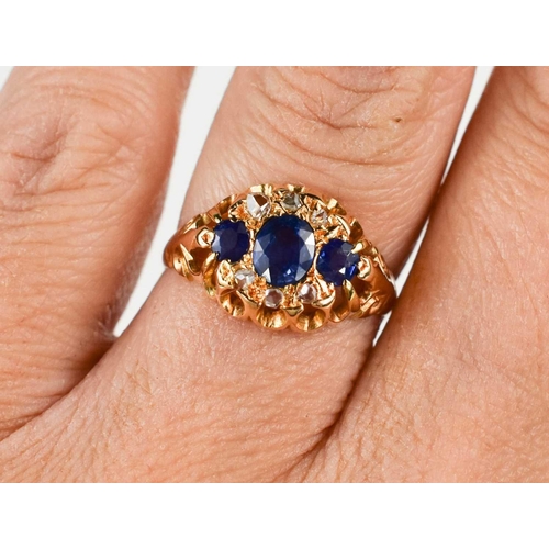 180 - A Victorian 18ct gold, blue and white sapphire dress ring, set with three graduated cornflower blue ... 