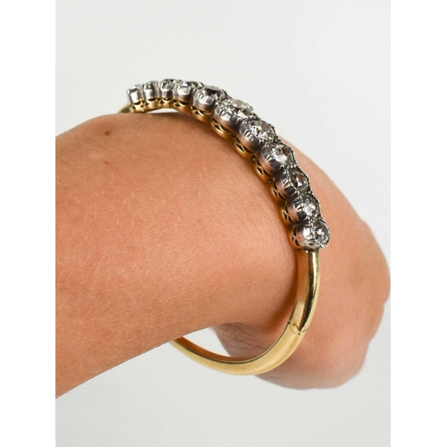 186 - A stunning and impressive diamond and 18ct gold bangle, set with eleven brilliant oval cut diamonds,... 