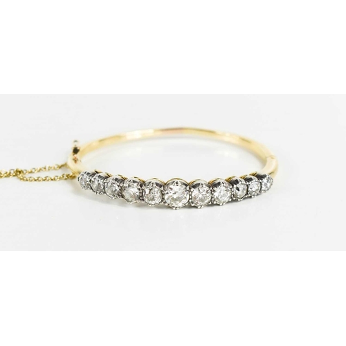 186 - A stunning and impressive diamond and 18ct gold bangle, set with eleven brilliant oval cut diamonds,... 