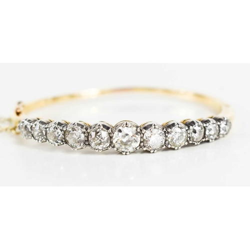 186 - A stunning and impressive diamond and 18ct gold bangle, set with eleven brilliant oval cut diamonds,... 