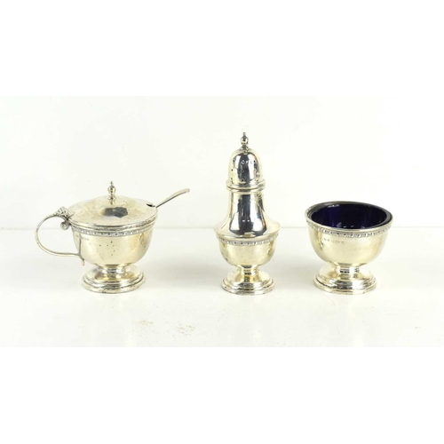 287 - A silver cruet set comprising salt, pepper and mustard, with blue glass liners.