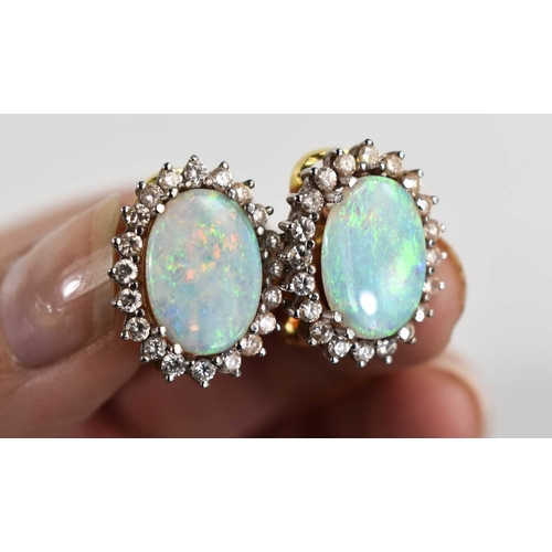 3 - A pair of 18ct gold, opal and diamond earrings, the oval opals of approximately 14 by 9.9 by 2.1mm, ... 