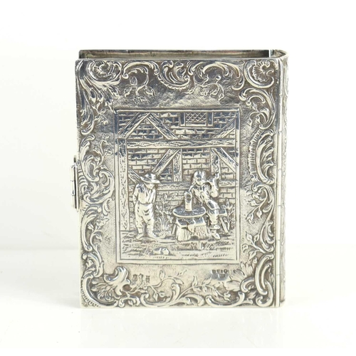 324 - An early 20th century Dutch silver tobacco box of book form with clasp, the box embossed with foliat... 