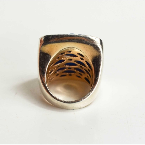 39 - A large Sterling silver ring with a large blue stone, likely agate, carved with a floral pattern wit... 