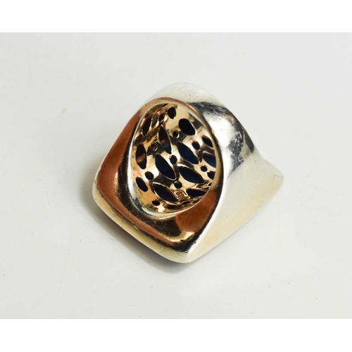 39 - A large Sterling silver ring with a large blue stone, likely agate, carved with a floral pattern wit... 