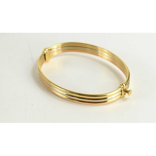 55 - A Cartier 18ct three tone gold bangle, the clasp in the form of a screw, with the original screwdriv... 