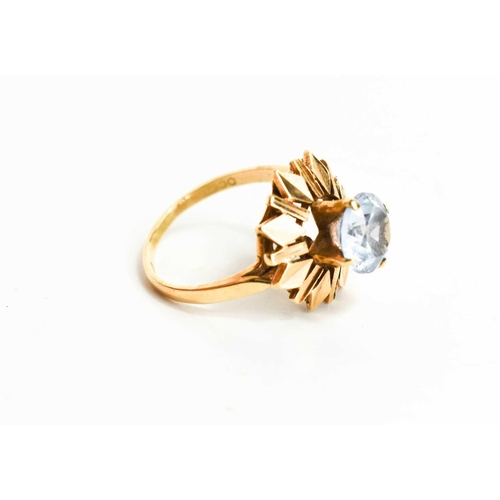 6 - A 9ct gold and aquamarine modernist ring, the raised claw set aquamarine of approximately 9mm diamet... 