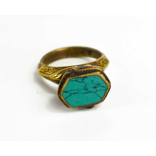 66 - A 19th century Byzantine style ring, the metal cast with horses on both sides of the setting, the to... 