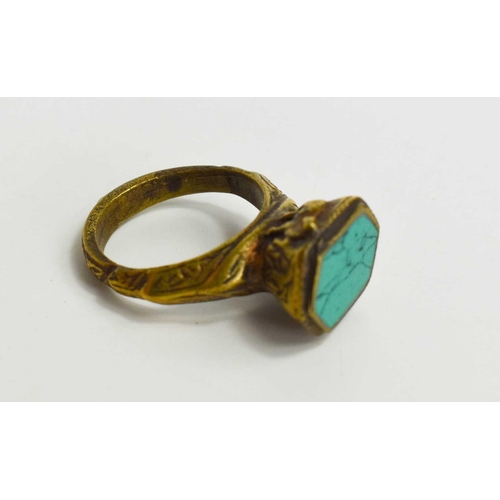 66 - A 19th century Byzantine style ring, the metal cast with horses on both sides of the setting, the to... 