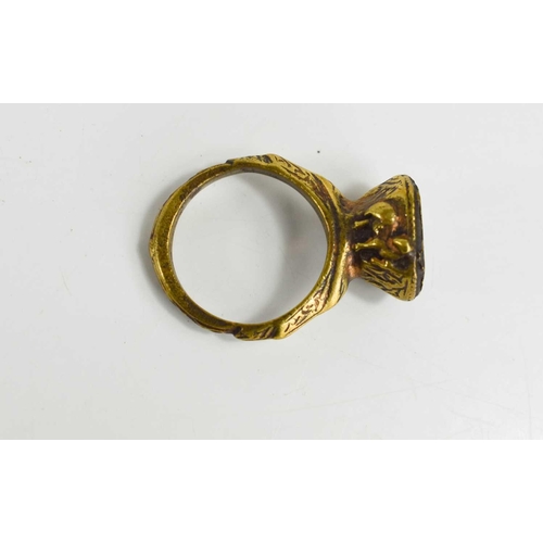 66 - A 19th century Byzantine style ring, the metal cast with horses on both sides of the setting, the to... 