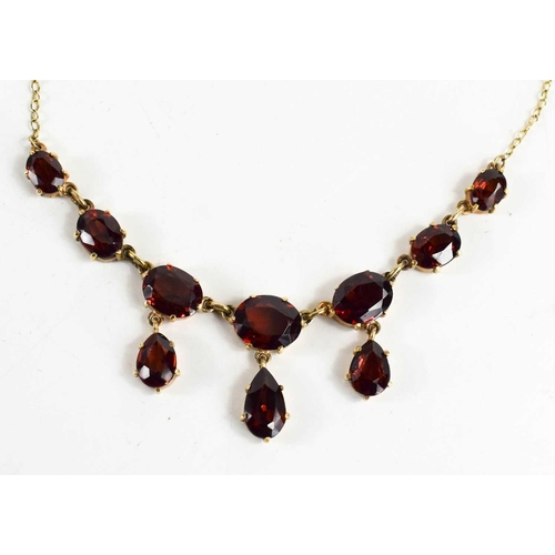 97 - A 9ct gold and garnet necklace, the front of seven graduated oval cut garnets with three pear cut dr... 