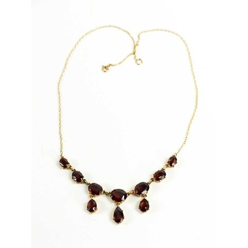 97 - A 9ct gold and garnet necklace, the front of seven graduated oval cut garnets with three pear cut dr... 