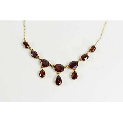 97 - A 9ct gold and garnet necklace, the front of seven graduated oval cut garnets with three pear cut dr... 