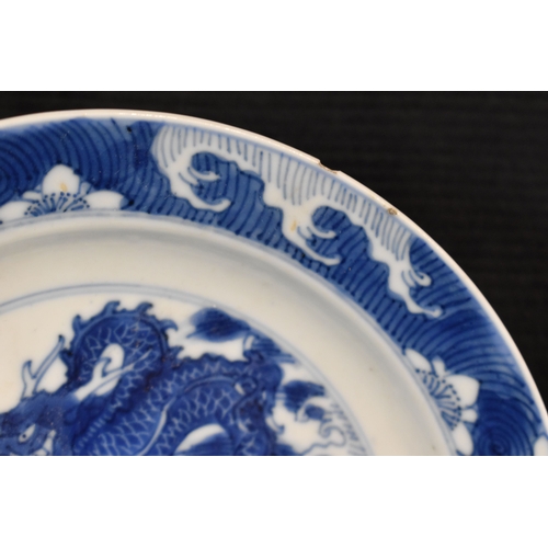 31 - A 19th century Qing period blue and white Chinese dish, depicting a dragon chasing a flaming pearl, ... 