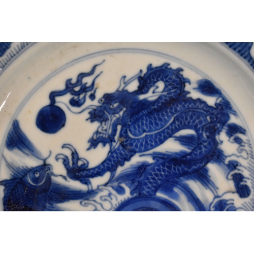 31 - A 19th century Qing period blue and white Chinese dish, depicting a dragon chasing a flaming pearl, ... 