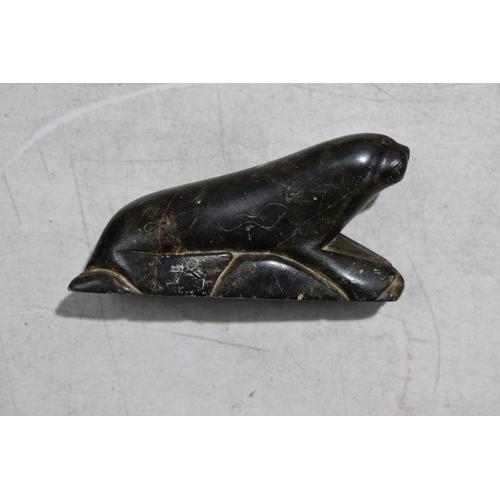 269 - A John Koonook Inuit stone sculpture of a hunter together with various stone carvings to include a T... 