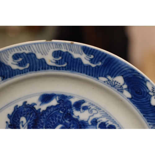 31 - A 19th century Qing period blue and white Chinese dish, depicting a dragon chasing a flaming pearl, ... 