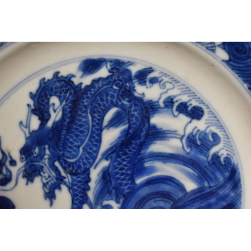 31 - A 19th century Qing period blue and white Chinese dish, depicting a dragon chasing a flaming pearl, ... 