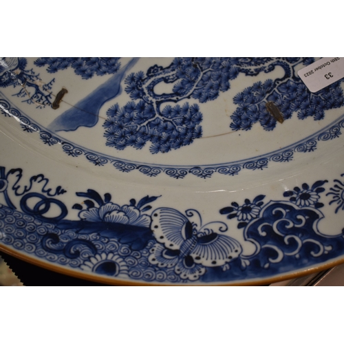 33 - An early 19th century Chinese blue and white charger, depicting a figure standing beside a tree with... 