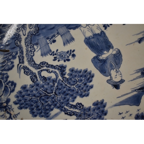 33 - An early 19th century Chinese blue and white charger, depicting a figure standing beside a tree with... 