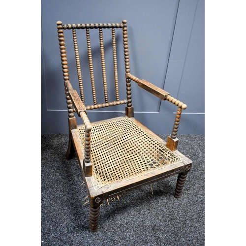 464 - A 19th century regional bobbin turned rosewood and caned armchair, the cane work A/F.