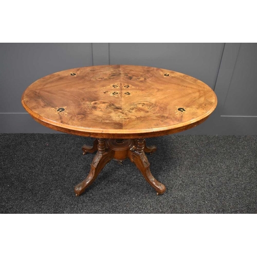 467 - A Victorian walnut marquetry inlaid breakfast table raised on four turned columns united by a centra... 