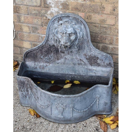 484 - A lead bow fronted water fountain, the arched back with lion mask decoration.