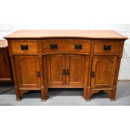 496 - An early 20th century Arts and Crafts oak dresser, with reverse bow top, fitted with three drawers a... 