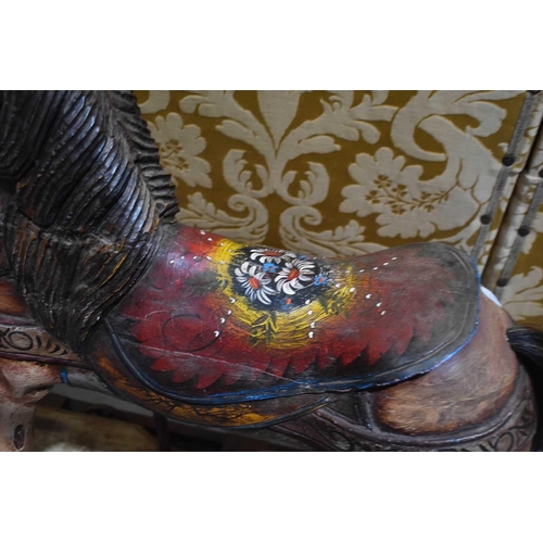 100 - A 20th century hand painted rocking horse, depicting flowers on the saddle. 85cm high.