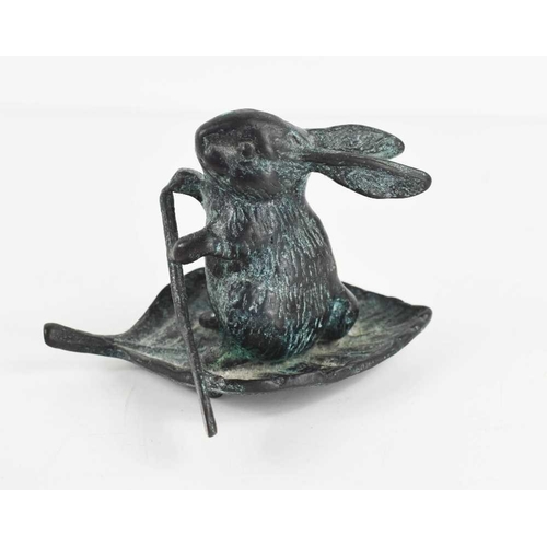 110 - A 20th century green patinated bronzed metal rabbit paddling on a leaf, 7.5cm high.