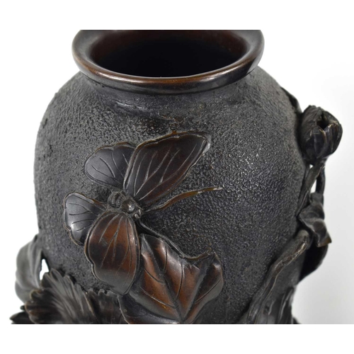 119 - A pair of Japanese bronze vases, with relief decoration depicting a butterfly among a sprays of flow... 