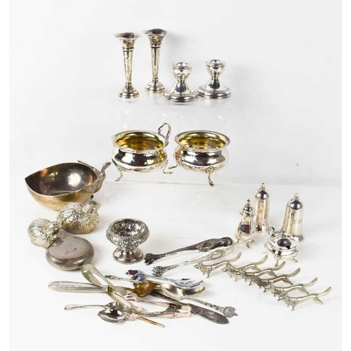 162 - A group of silver to include a pair of candlesticks, 6cm high, pair of bud vases 10cm high, an embos... 