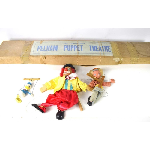 21 - A vintage Pelham Puppet Theatre in the original box together with a Pelham Puppet, a clown puppet an... 