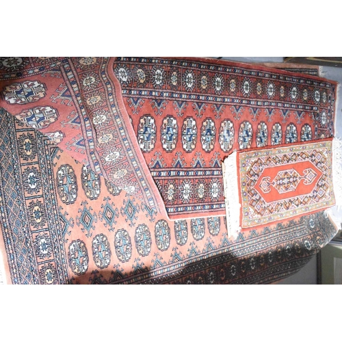 605 - A Middle Eastern peach ground rug, a runner of similar pattern with darker peach ground, and a small... 