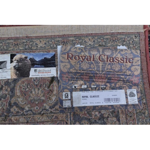 606 - A Royal Classic rug made from New Zealand wool, red ground with floral decoration, 170cm by 246cm, t... 