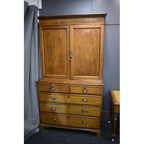 658 - A Georgian oak cabinet on chest, the upper portion with moulded cornice over a pair of panelled door... 