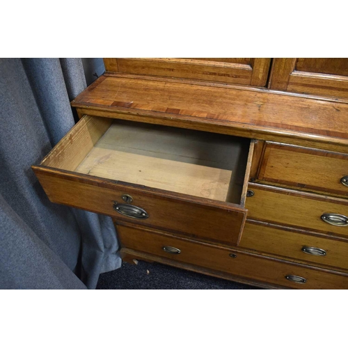 658 - A Georgian oak cabinet on chest, the upper portion with moulded cornice over a pair of panelled door... 