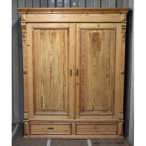 663 - An antique pine double Wardrobe, with panel doors and two drawers, 195cm by 152cm by 60cm.