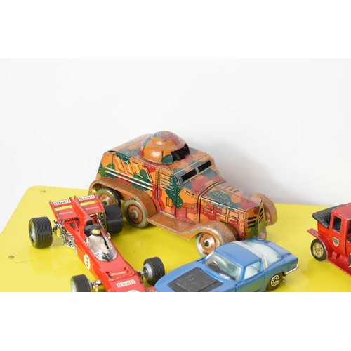 84 - A collection of vintage toy vehicles, including various tin-plate clockwork examples, Britains, Corg... 