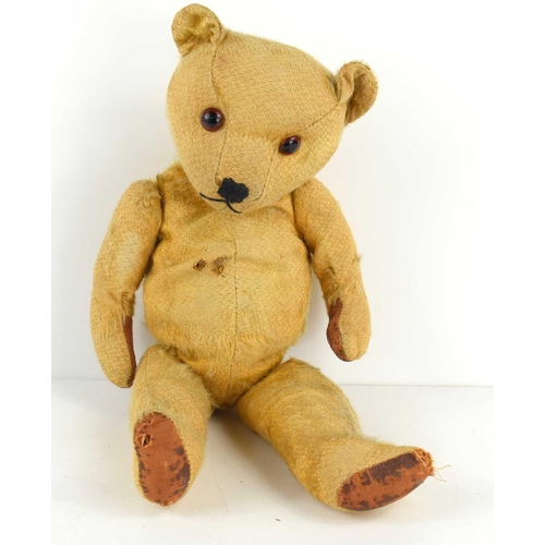 85 - A vintage teddy bear, circa 1938, having straw filled jointed body, and glass eyes, 40 cm long.