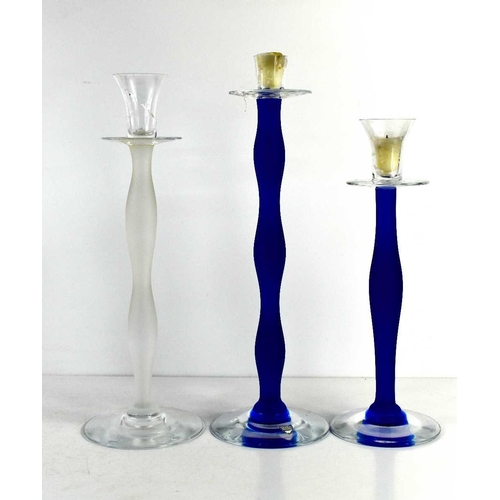 13 - Three Orrefors of Sweden glass candlesticks by Celeste Anne Nilsson, two with blue opaque stems, the... 