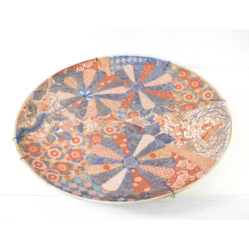 298 - A large 19th century Japanese Imari charger, decorated with patterns of fans and panels of flowers, ... 