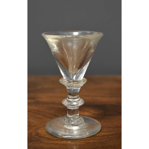 88 - A late 18th century toast master's or firing glass, with flared conical bowl, deceptive base, and tr... 