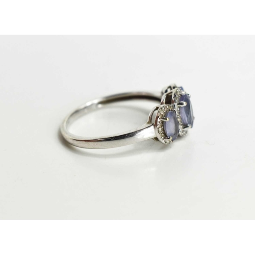 110 - A 9ct white gold and lavender amethyst and diamond three stone ring, the graduated oval amethysts ea... 