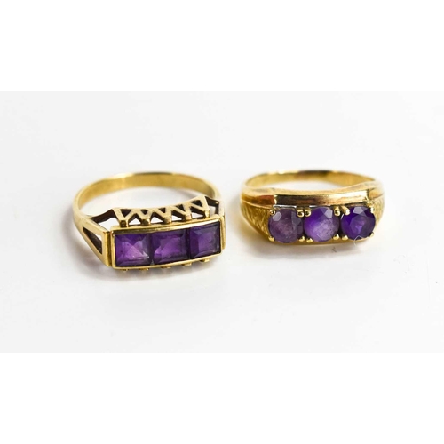 111 - Two amethyst three stone rings, one set with emerald cut stones, size Q, 2.6g, the other set with ro... 